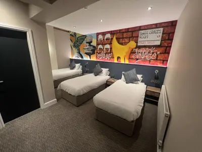 a room with two beds and a mural on the wall at Fenwick Sunrise Hotel in Liverpool