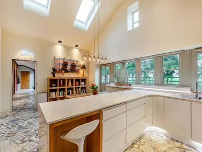 a large kitchen with white cabinets and windows at The Stables in Longridge