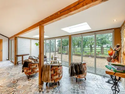 a living room with windows and a table and chairs at The Stables in Longridge