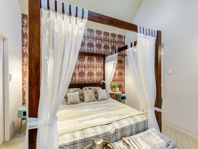 a bedroom with a canopy bed with white curtains at The Stables in Longridge