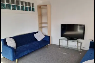 a living room with a blue couch and a tv at Apt - Sleeps 7 - Walking Distance to Attractions in Liverpool
