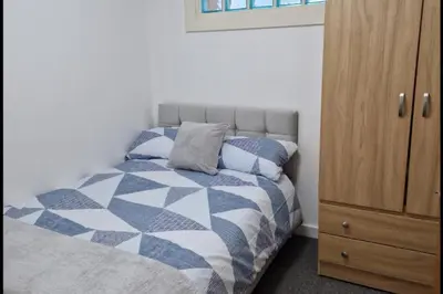 a bedroom with a bed and a wooden cabinet at Apt - Sleeps 7 - Walking Distance to Attractions in Liverpool
