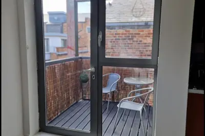 a door to a balcony with a table and chairs at Apt - Sleeps 7 - Walking Distance to Attractions in Liverpool