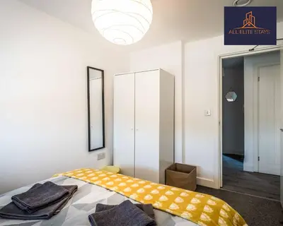 a bedroom with a bed with a yellow blanket on it at Swan House Apartment 7 - 2 Bed Apartment - Sleeps 5 - Free Parking - Liverpool - close to city centre - By ALL ELITE STAYS in Liverpool