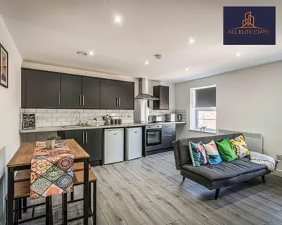 a kitchen and living room with a couch and a table at Swan House Apartment 7 - 2 Bed Apartment - Sleeps 5 - Free Parking - Liverpool - close to city centre - By ALL ELITE STAYS in Liverpool