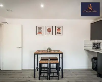 a table with two stools in front of a white wall at Swan House Apartment 7 - 2 Bed Apartment - Sleeps 5 - Free Parking - Liverpool - close to city centre - By ALL ELITE STAYS in Liverpool