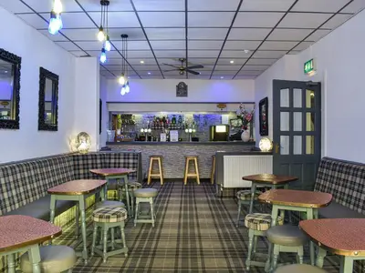 a restaurant with tables and stools and a bar at Apartment 786 At The Granville in Blackpool