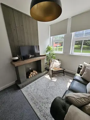 a living room with a couch and a fire place at Shakespeare's Snug in Prescot