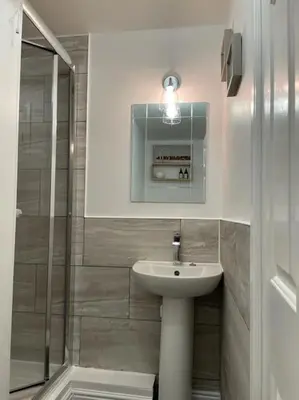 a bathroom with a sink and a glass shower at Shakespeare's Snug in Prescot