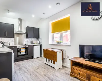 a kitchen with black and white appliances and a tv at Swan House Stunning 1 bed Apartment By ALL ELITE STAYS - near Liverpool city centre - Sleeps 4 - Free Parking in Liverpool