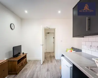 a kitchen with a counter and a tv on a table at Swan House Stunning 1 bed Apartment By ALL ELITE STAYS - near Liverpool city centre - Sleeps 4 - Free Parking in Liverpool
