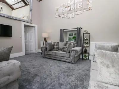 a living room with a couch and a mirror at Clarence House in Dalton in Furness