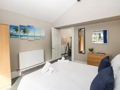 a bedroom with a white bed and a dresser at Clarence House in Dalton in Furness