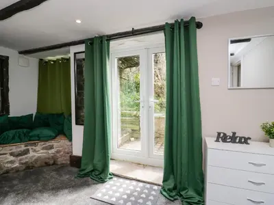 a living room with green curtains and a window at Clarence House in Dalton in Furness