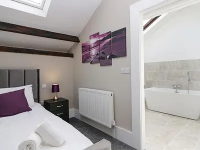 a bedroom with a king sized bed and a bath tub at Clarence House in Dalton in Furness
