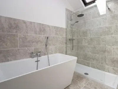 a bathroom with a bath tub and a shower at Clarence House in Dalton in Furness