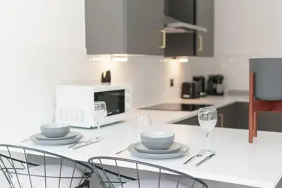 a kitchen with a table with plates and wine glasses at Modern 1 Bedroom Apartment in Preston Centre in Preston