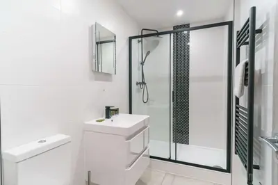 a white bathroom with a shower and a sink at Modern 1 Bedroom Apartment in Preston Centre in Preston