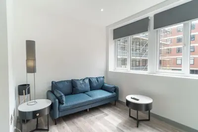 a living room with a blue couch and two tables at Modern 1 Bedroom Apartment in Preston Centre in Preston