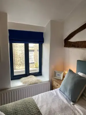a bedroom with a bed and a window at 1750's cottage with open fire and beams in Upholland