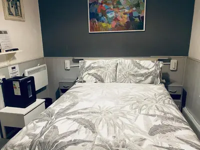 a bedroom with a bed and a painting on the wall at Bromptons in Blackpool