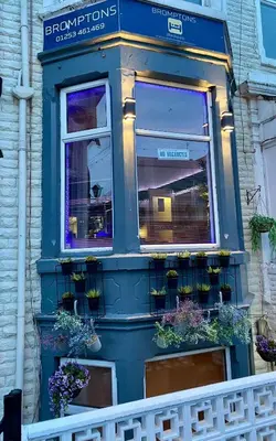 a blue building with potted plants on it at Bromptons in Blackpool