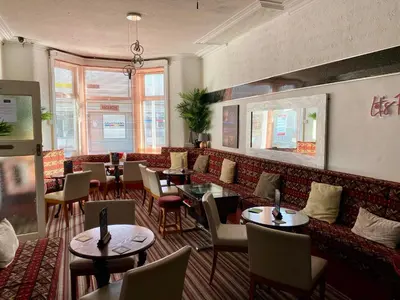 a restaurant with tables and chairs in a room at Bromptons in Blackpool