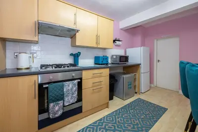 a kitchen with wooden cabinets and a stove top oven at GuestReady - Charming haven in Knowledge Quarter in Liverpool