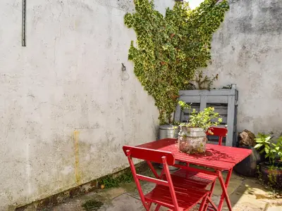 a red table with two chairs and a plant at Waterloo Sunset in Bootle