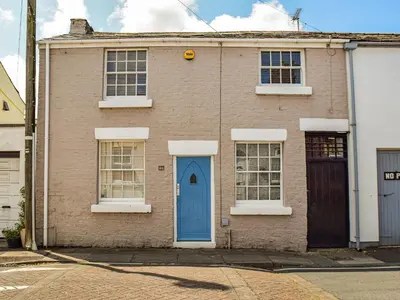 an old brick house with a blue door at Waterloo Sunset in Bootle
