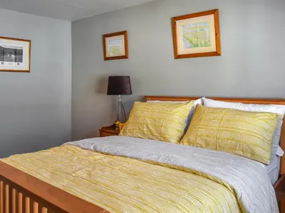 a bedroom with a bed with yellow sheets and a lamp at Waterloo Sunset in Bootle
