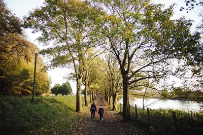 two people walking down a path next to a river at 7 Cannon Street in Preston