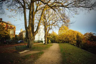 a path in a park with trees and a building at 7 Cannon Street in Preston