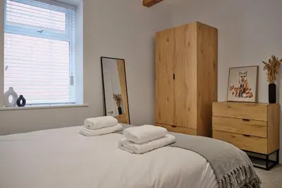 a bedroom with two beds with white sheets and a dresser at 7 Cannon Street in Preston