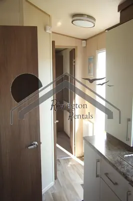 a kitchen with a staircase leading into a hallway at The Rivington Lodge in Heysham