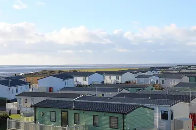 a row of houses with the ocean in the background at The Rivington Lodge in Heysham