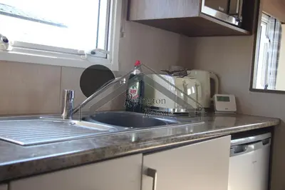 a kitchen counter with a sink and a microwave at The Rivington Lodge in Heysham