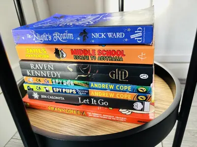 a stack of books sitting on a chair at Stylish 3BR house near Liverpool Football Club in Liverpool