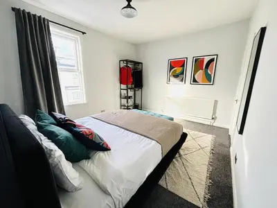 a bedroom with a bed with pillows and a window at Stylish 3BR house near Liverpool Football Club in Liverpool
