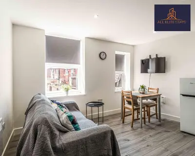 a living room with a couch and a table at Swan House Apartment 2 - 1 Bed Apartment - Sleeps up to 4 - Free Parking - Liverpool - close to city centre - By ALL ELITE STAYS in Liverpool