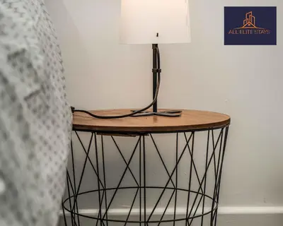 a table with a lamp on it next to a bed at Swan House Apartment 2 - 1 Bed Apartment - Sleeps up to 4 - Free Parking - Liverpool - close to city centre - By ALL ELITE STAYS in Liverpool
