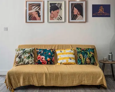a couch with pillows and pictures on a wall at Swan House Apartment 5 - 2 Bed Apartment - Sleeps 6 - Free Parking - Liverpool - close to city centre - By ALL ELITE STAYS in Liverpool