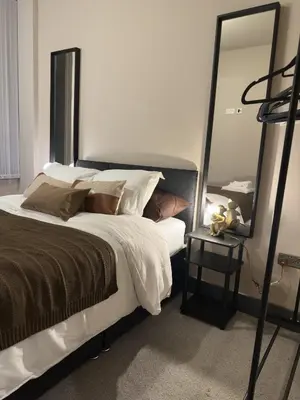 a bedroom with a large bed with a large mirror at Elegant and Sophisticated, and we mean it! in Liverpool