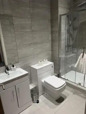 a white bathroom with a toilet and a shower at Elegant and Sophisticated, and we mean it! in Liverpool