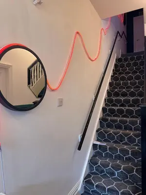 a mirror on the wall next to a staircase at Quirky House Blackpool in Blackpool