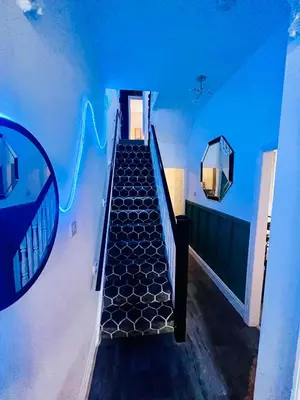 a staircase in a room with blue lights at Quirky House Blackpool in Blackpool