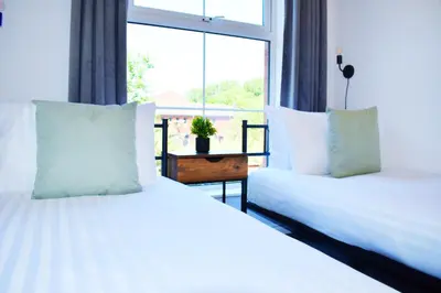 two beds in a room with a large window at City Center Apartments FREE PARKING in Liverpool