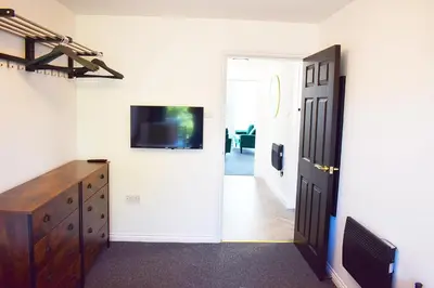 a room with a tv on the wall and a door at City Center Apartments FREE PARKING in Liverpool