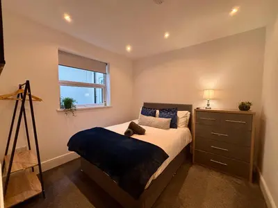 a bedroom with a bed with a dresser and a window at Franks Apt 1 - Outdoor Courtyard - Sleeps 6 in Blackpool