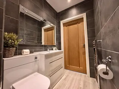 a bathroom with a toilet and a sink and a mirror at Franks Apt 1 - Outdoor Courtyard - Sleeps 6 in Blackpool